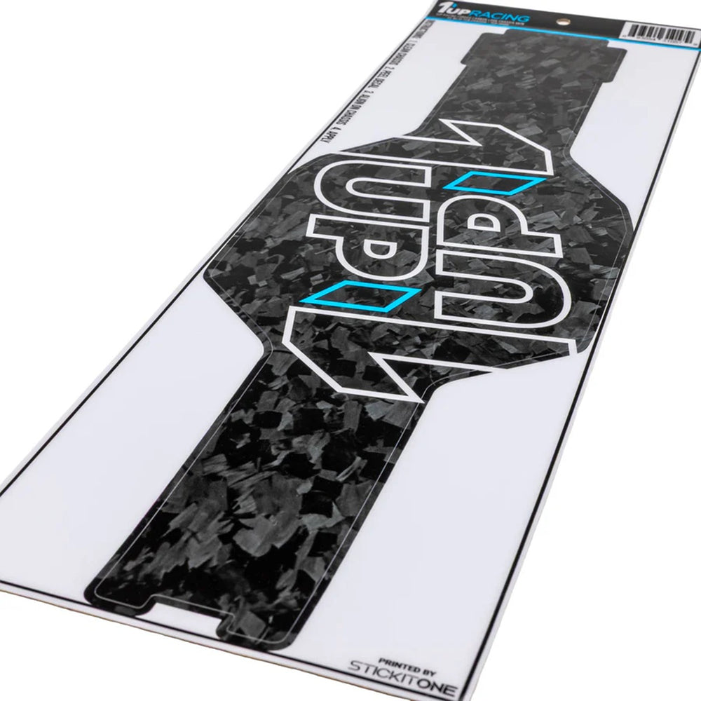 1UP Racing - Forged Carbon Look Chassis Skin - AE RC10 Tub Chassis displayed on white backing, featuring black carbon texture with bold white and blue logo, perfect for enhancing RC car aesthetics with a veteran-owned, STEM-focused brand.