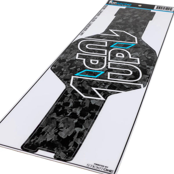 1UP Racing - Forged Carbon Look Chassis Skin - AE RC10 Tub Chassis displayed on white backing, featuring black carbon texture with bold white and blue logo, perfect for enhancing RC car aesthetics with a veteran-owned, STEM-focused brand.