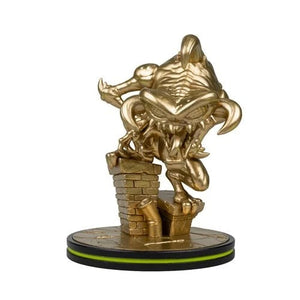 A gold-colored collectible figurine of a monstrous creature climbing a brick wall, mounted on a circular black and gold base with a thin green accent line, set against a plain white background.