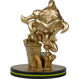 A metallic gold collectible figurine of a monstrous creature climbing a brick wall, mounted on a round black and gold base with a bright green ring accent, isolated on a white background.