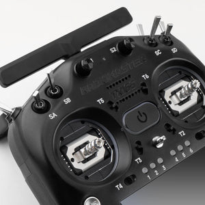 Close-up of a black radio control transmitter with visible branding on a white background