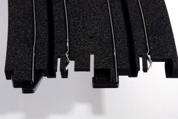 Echo Six Hobbies AFX Racing Close-up of black HO Slot Car track with textured surface on a white background