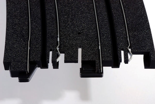 Echo Six Hobbies AFX Racing Close-up of black plastic interlocking puzzle pieces on a white background