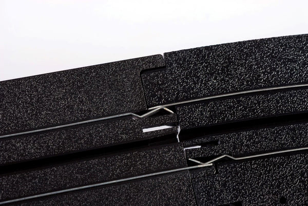 Echo Six Hobbies AFX Racing Close-up of black HO Slot car track with a white background
