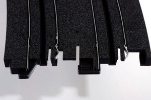 Echo Six Hobbies AFX Racing Close-up of black plastic interlocking puzzle pieces on a white background