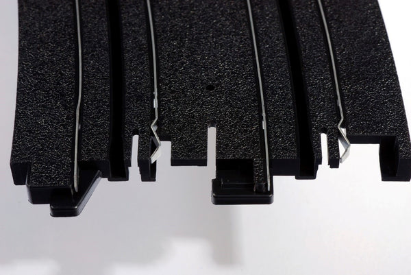 Echo Six Hobbies AFX Racing Close-up of black plastic interlocking puzzle pieces on a white background