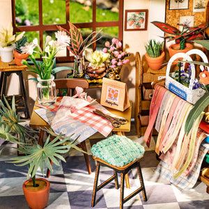 Miniature room setup with furniture, plants, and decor items.