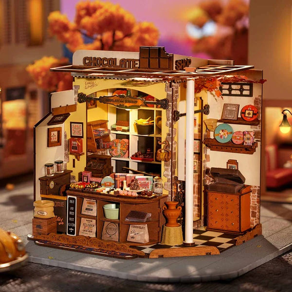 Miniature model of a chocolate shop with detailed interior and lighting.
