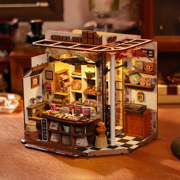 Miniature model of a chocolate shop with detailed interior on a table.