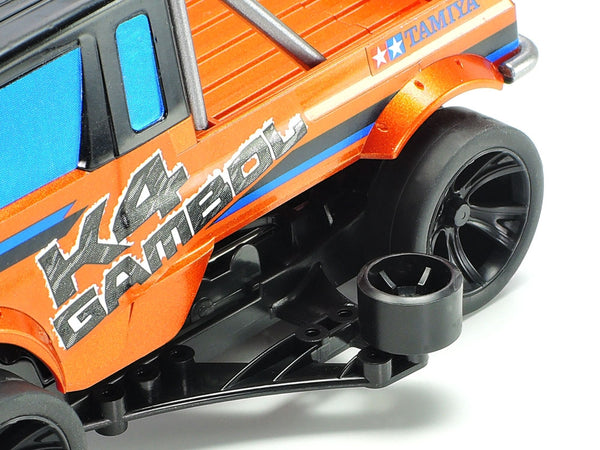 Close-up of an orange model truck with 'K4 Gambol' and 'Tamiya' branding on a white background.