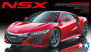 Red Honda NSX model car on a black background with Tamiya branding.
