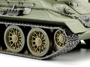 Close-up of a green tank model with wheels and tracks on a white background