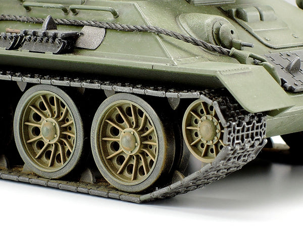 Close-up of a green tank model with wheels and tracks on a white background