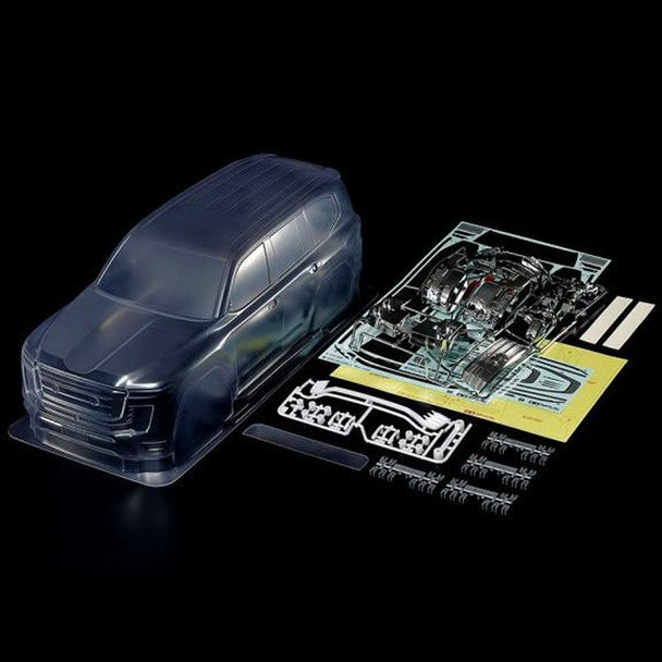 A transparent plastic model car body kit shown next to its exposed internal frame, decals, and assembly parts on a solid black background.