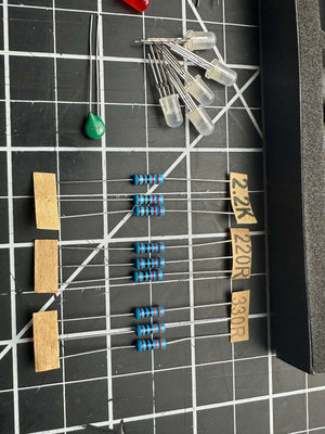 Make: Getting Started with Oxocard Connect - PDF features close-up of electronic components including resistors and LEDs arranged on a grid cutting mat, reflecting hands-on STEM electronics learning.