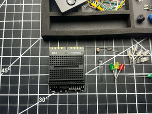 Make: Getting Started with Oxocard Connect - PDF shown with electronic components and LEDs on a craft grid mat, highlighting hands-on STEM learning for enthusiasts and builders.