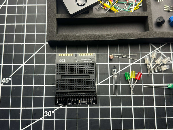 Make: Getting Started with Oxocard Connect - PDF shown with electronic components and LEDs on a craft grid mat, highlighting hands-on STEM learning for enthusiasts and builders.