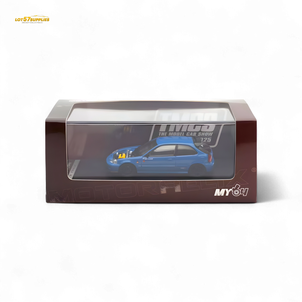 Blue model car with black roof and black wheels on a white background, displayed in front of its packaging.