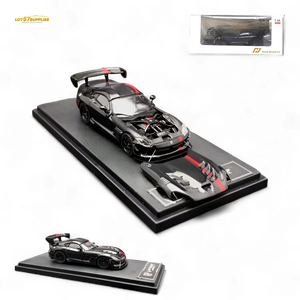 Black sports car model with tools on a display stand, accompanied by its packaging.