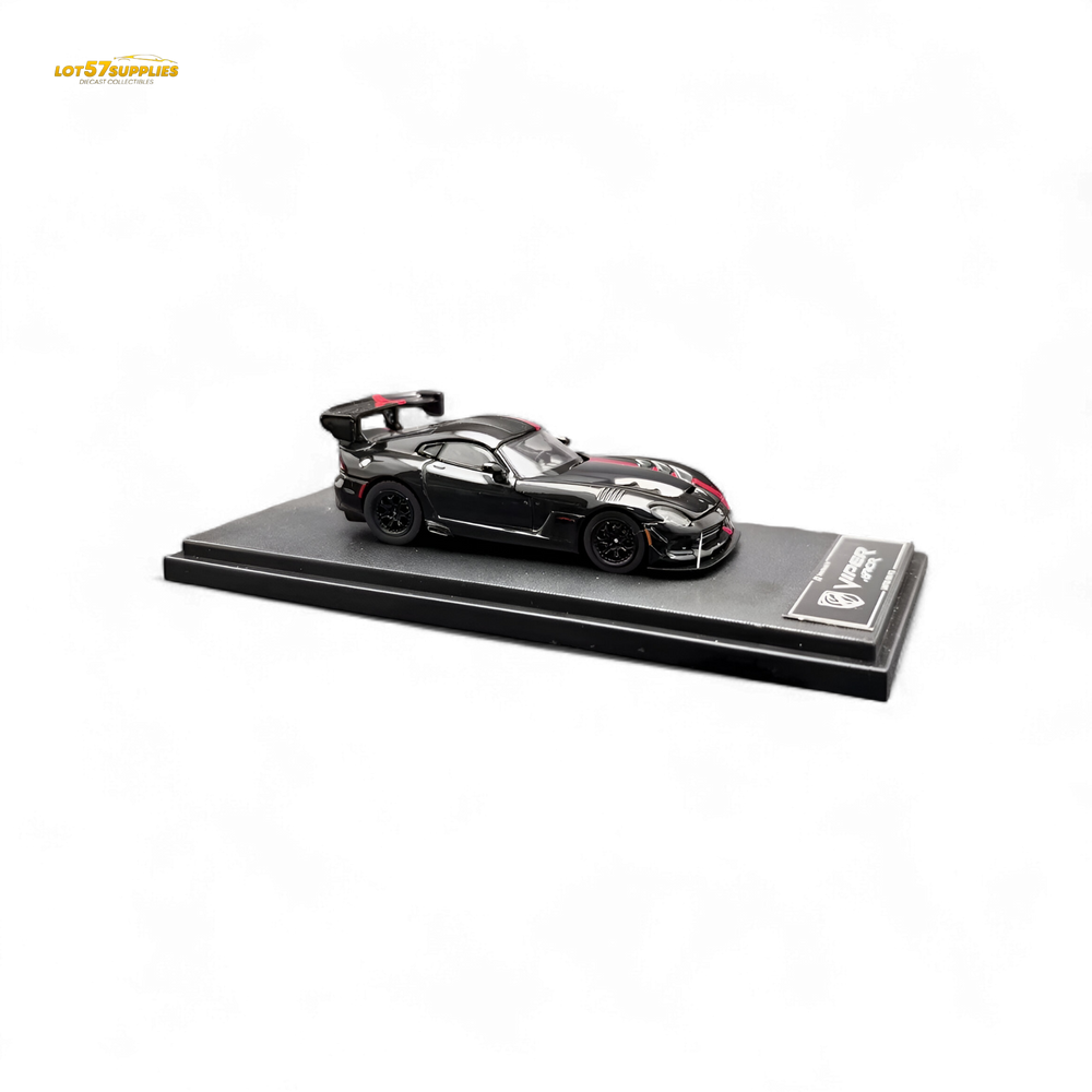 Black sports car model with tools on a display stand, accompanied by its packaging.